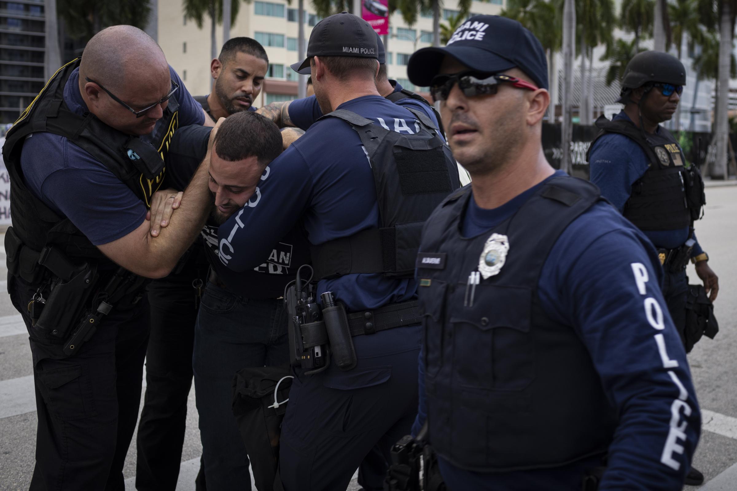 Pro-Palestine demonstration in Miami - Miami Police officers detain a demonstrator as people...