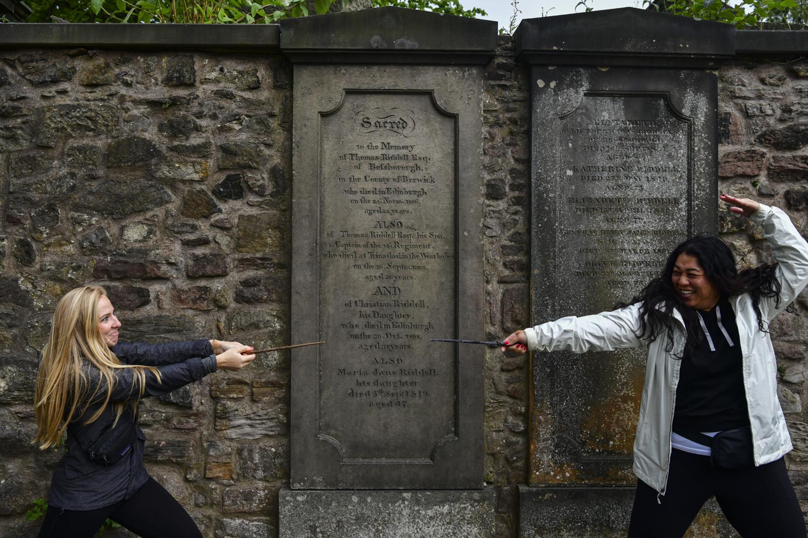 Image from Daily Life UK - Tourists play with wands in front of the grave of a...