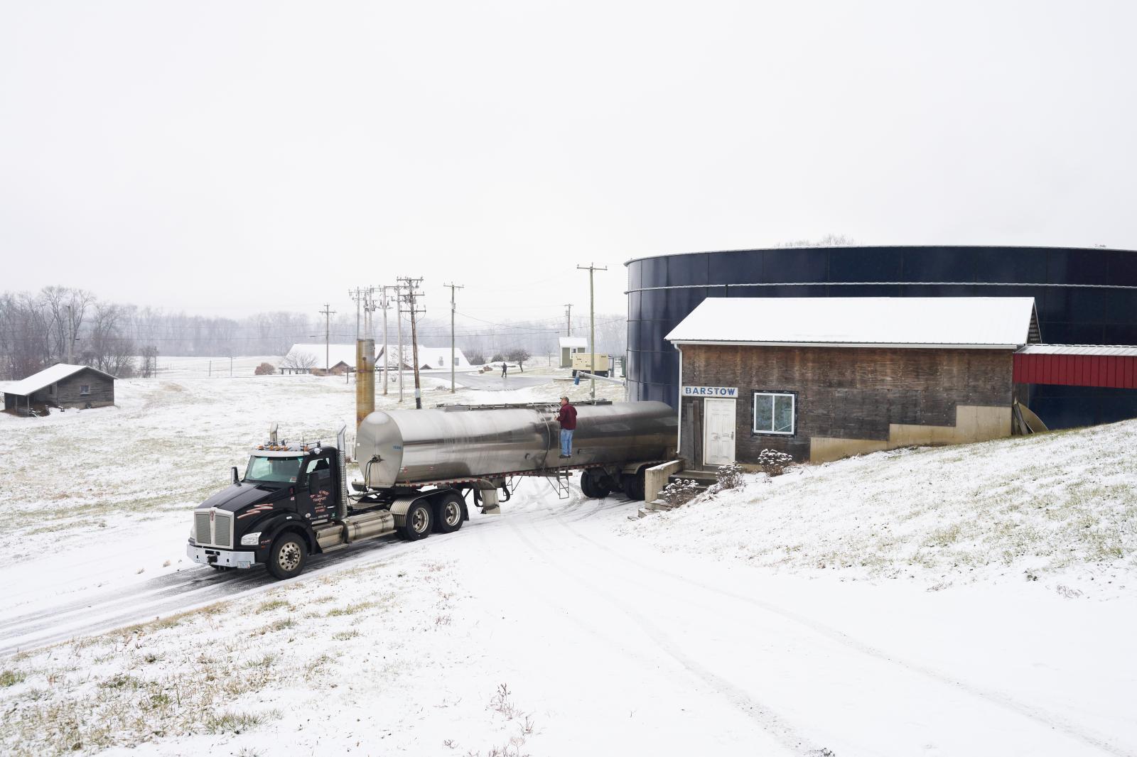 The Smithsonian Magazine: Manure Into Money - Hadley, Massachusetts - January 12: A milk truck fills up, while the large blue tank behind holds...