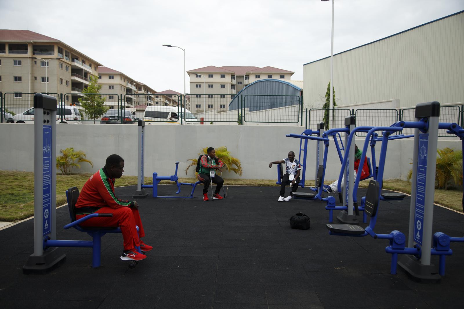 Image from First African Para Games  - Some para-athletes sit at an outside gym at the first...