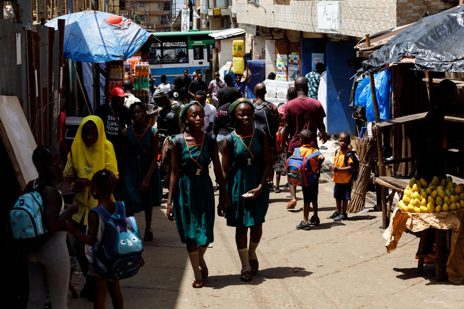 School girls walk in Bombay com... services are severely limited.