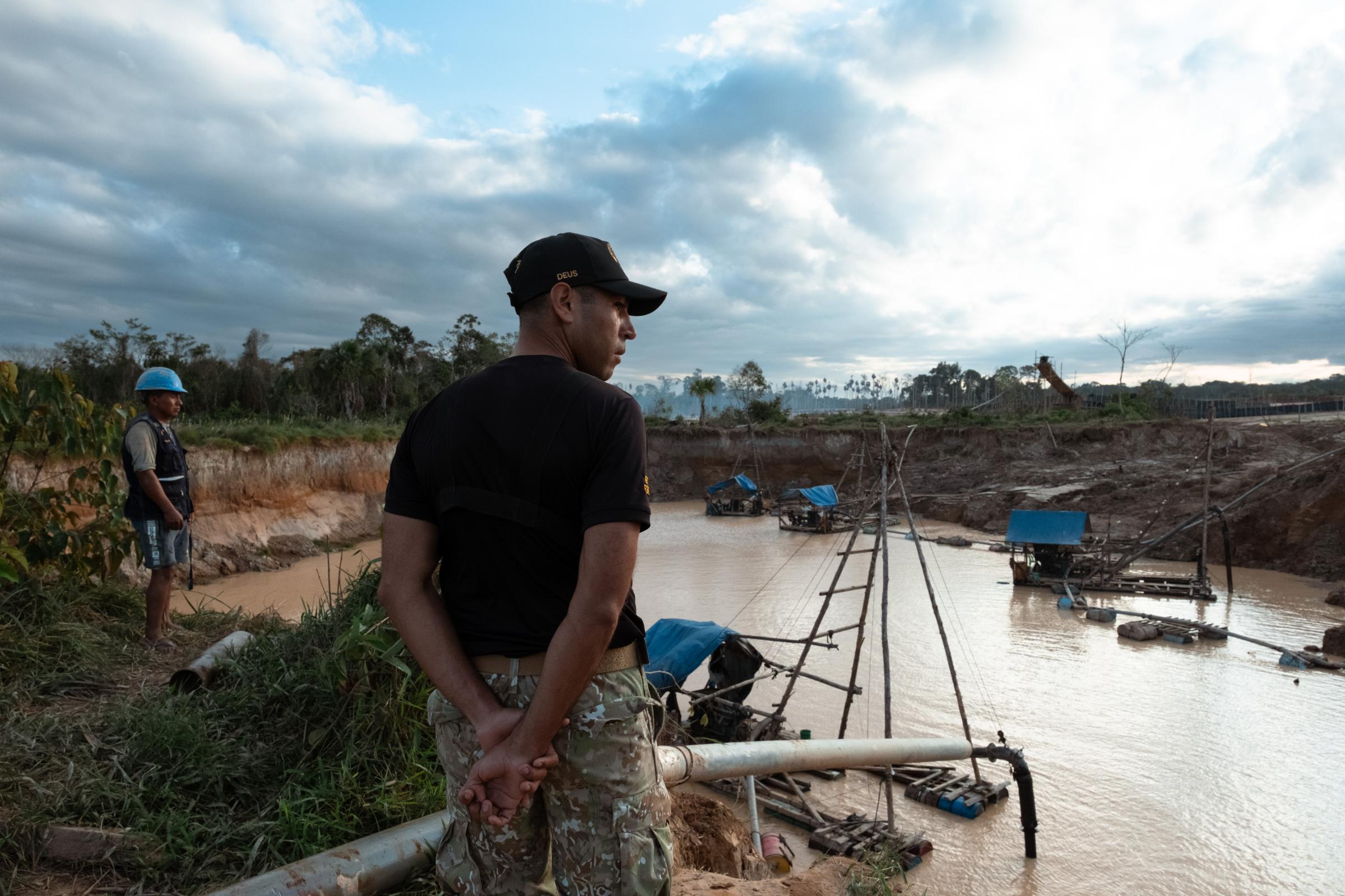 Illegal Gold Mining in La Pampa - A military man observes the pit from which gold is...
