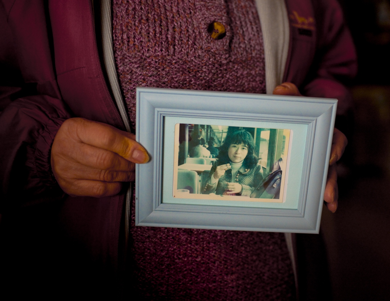  Tokiko Kitazaki, an evacuee from Tomioka-machi, Fukushima. A mushroom and rice farmer a good portion of her life and mother of two, holds an old photograph of herself when she was 25 years old. "Life is different now, things will never be the same," she says. Tomioka evacuee houses, Koriyama, Japan. Feb. 2014 