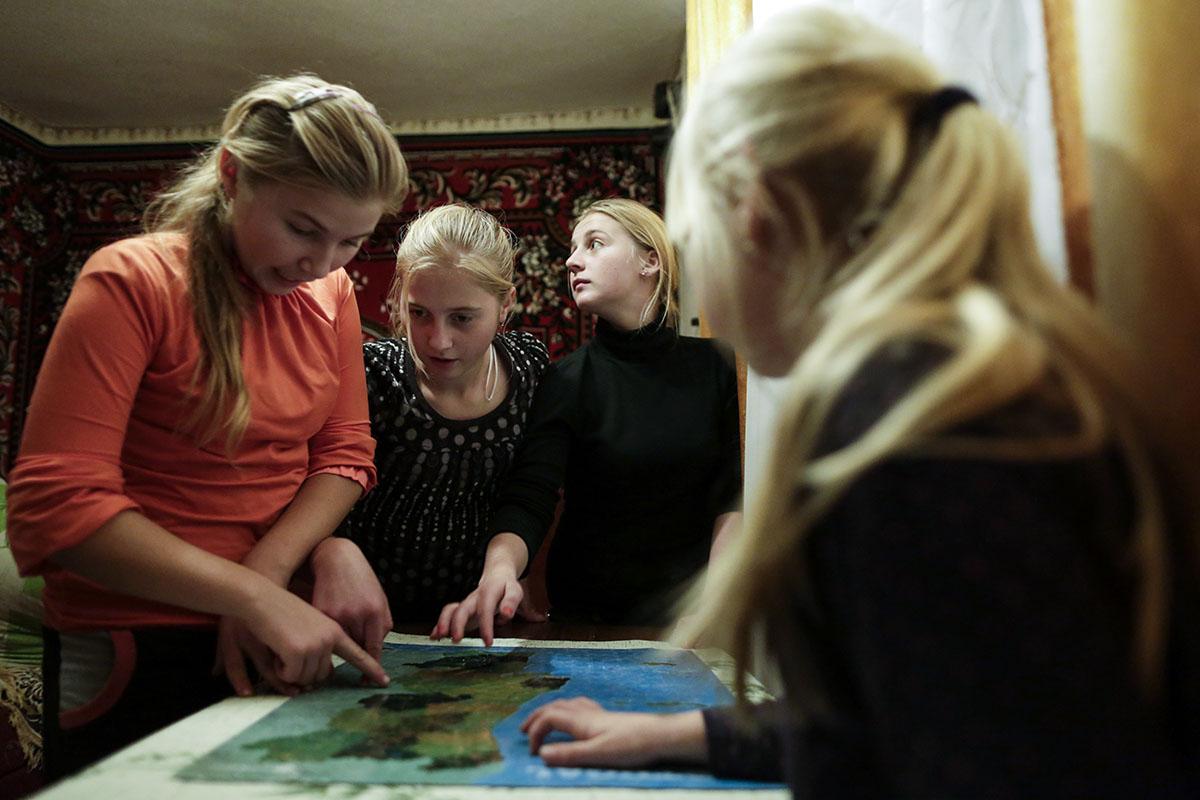 From Chernobyl With Love - Karolina Vasyanovych, 15 (second on the left) and her sisters try to figure out in the Map at...