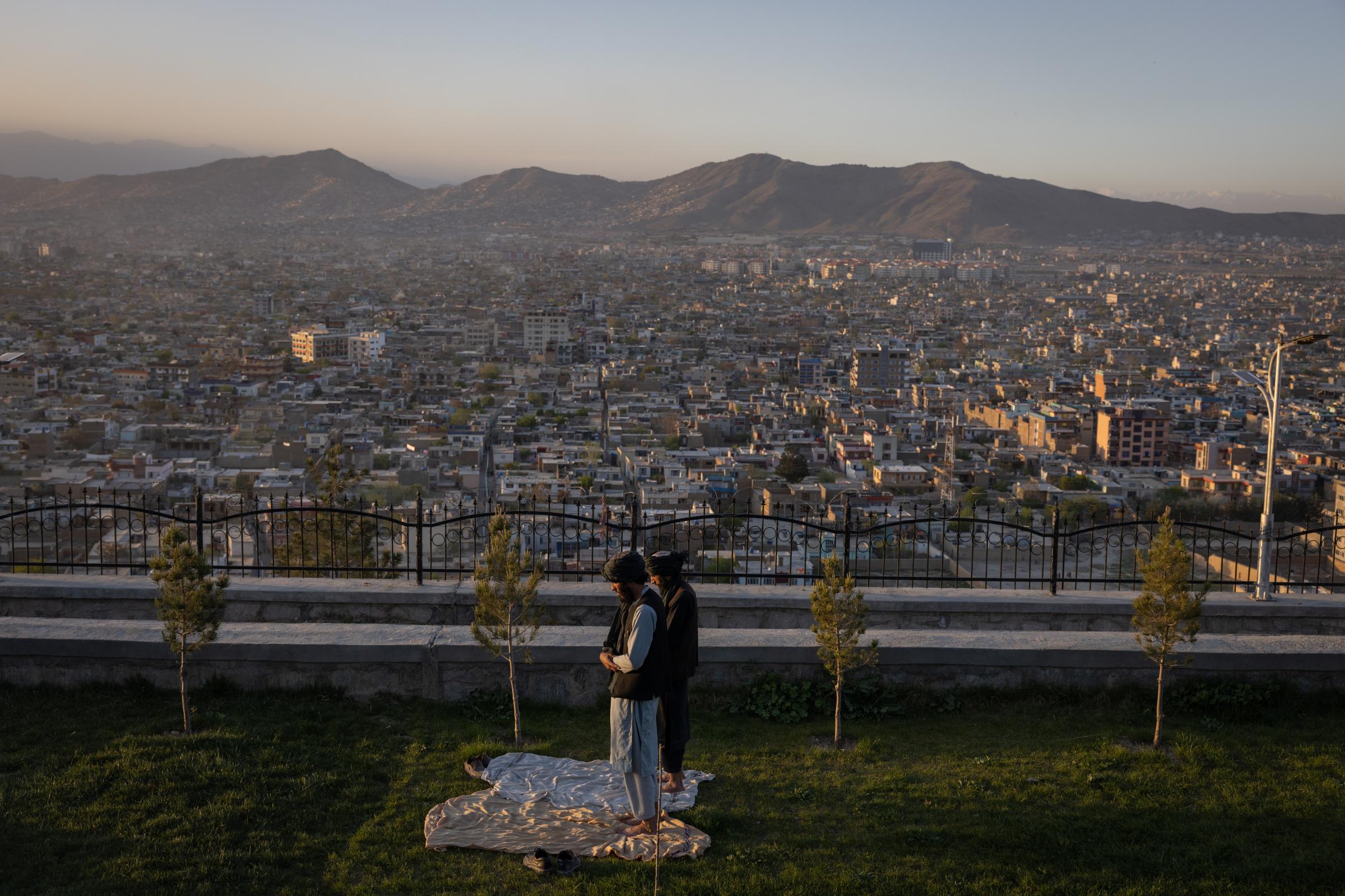 Two Taliban pray in the evening sun on Wazir Akbar Khan hill in Kabul.