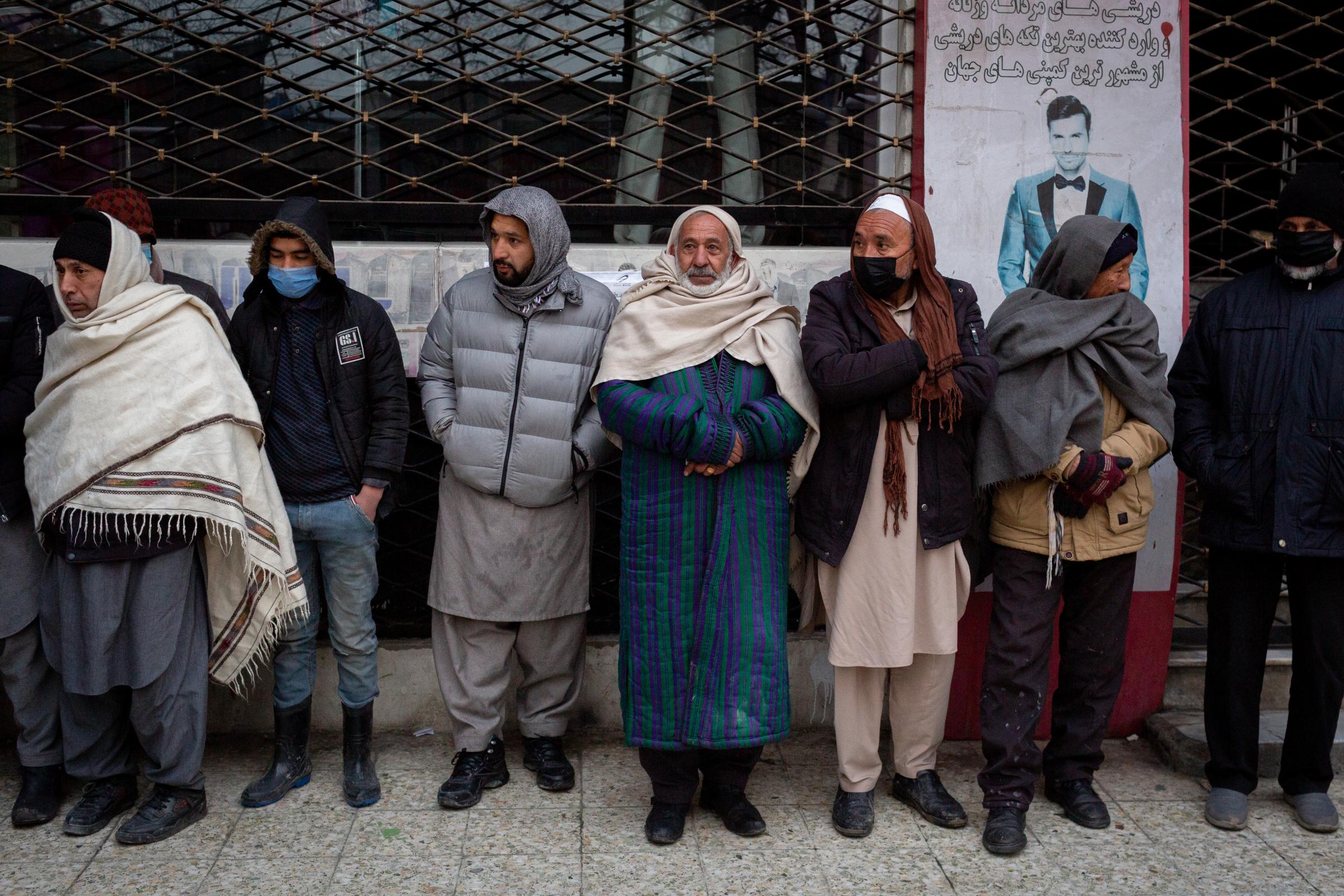 Men wait outside of the Central Bank in Kabul for withdrawing money. In cause of the sanctions...