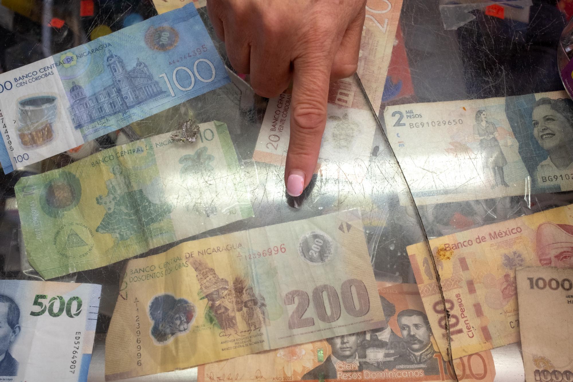 ProPublica - Immigration  - Eva Aranda points at Nicaraguan money that she keeps...