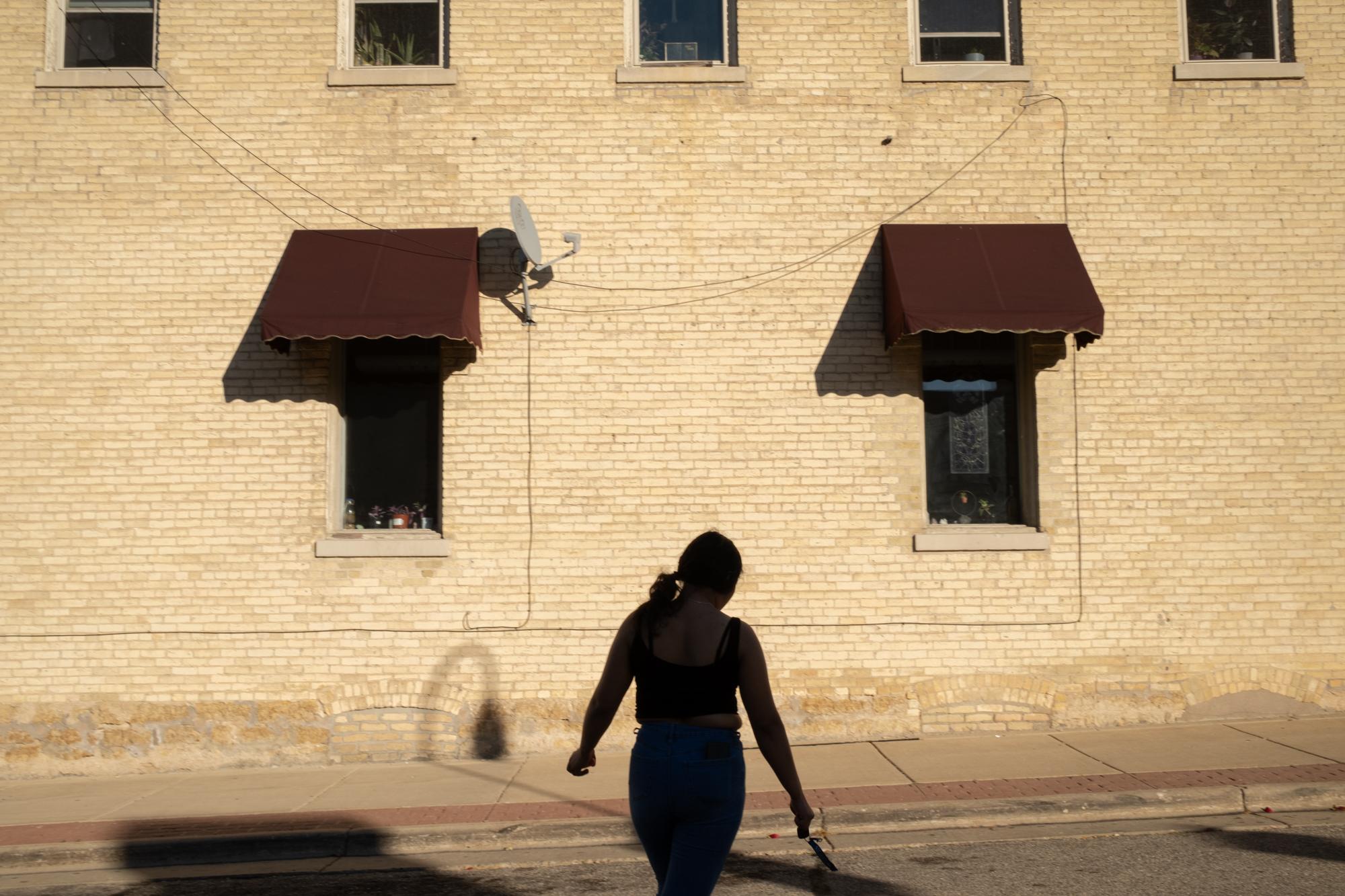 ProPublica - Immigration  - Monica walks across the street in downtown Whitewater,...