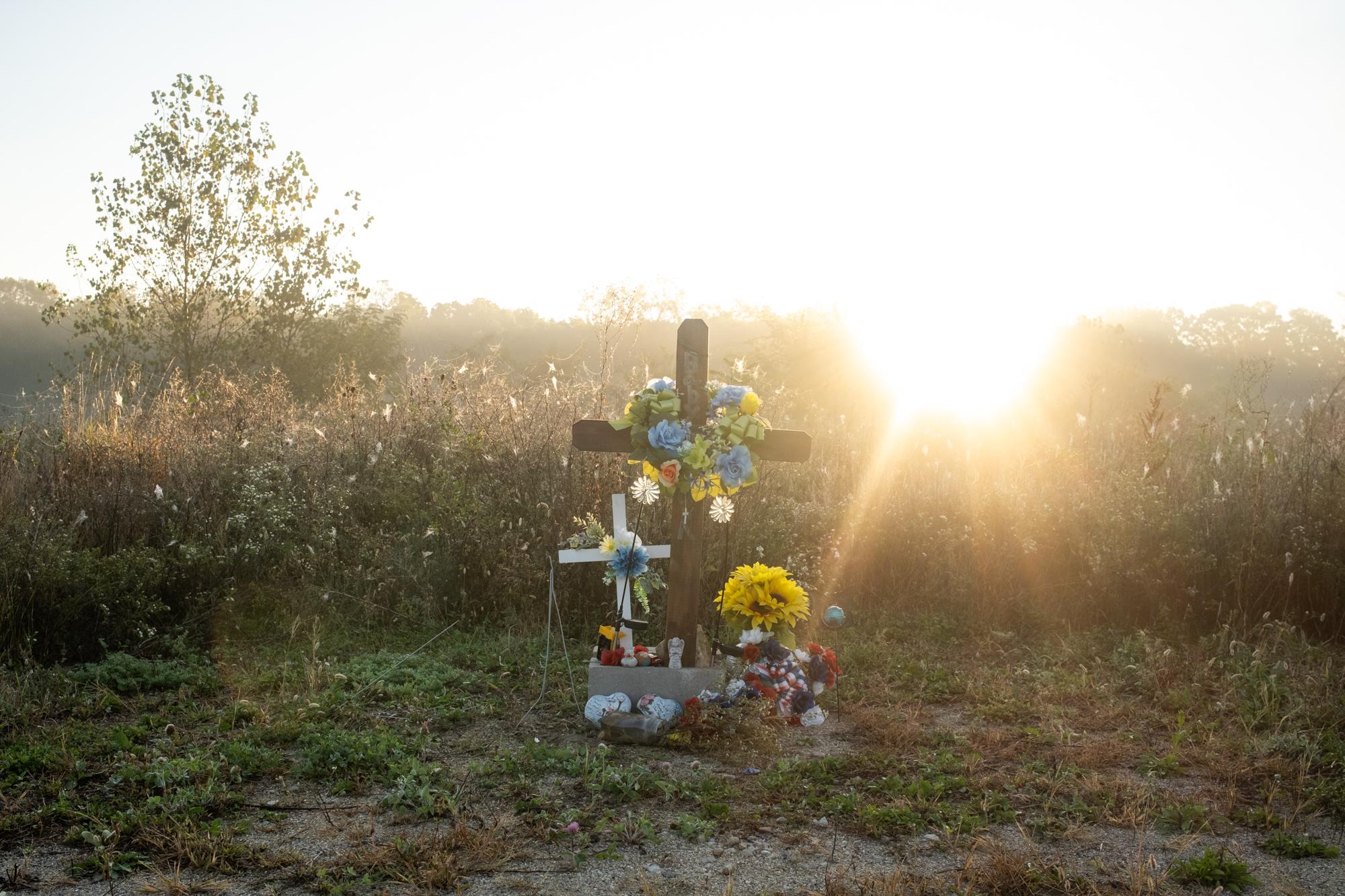 ProPublica - Immigration  - Adorns hang on a cross at the end of a road at Twin Oaks...