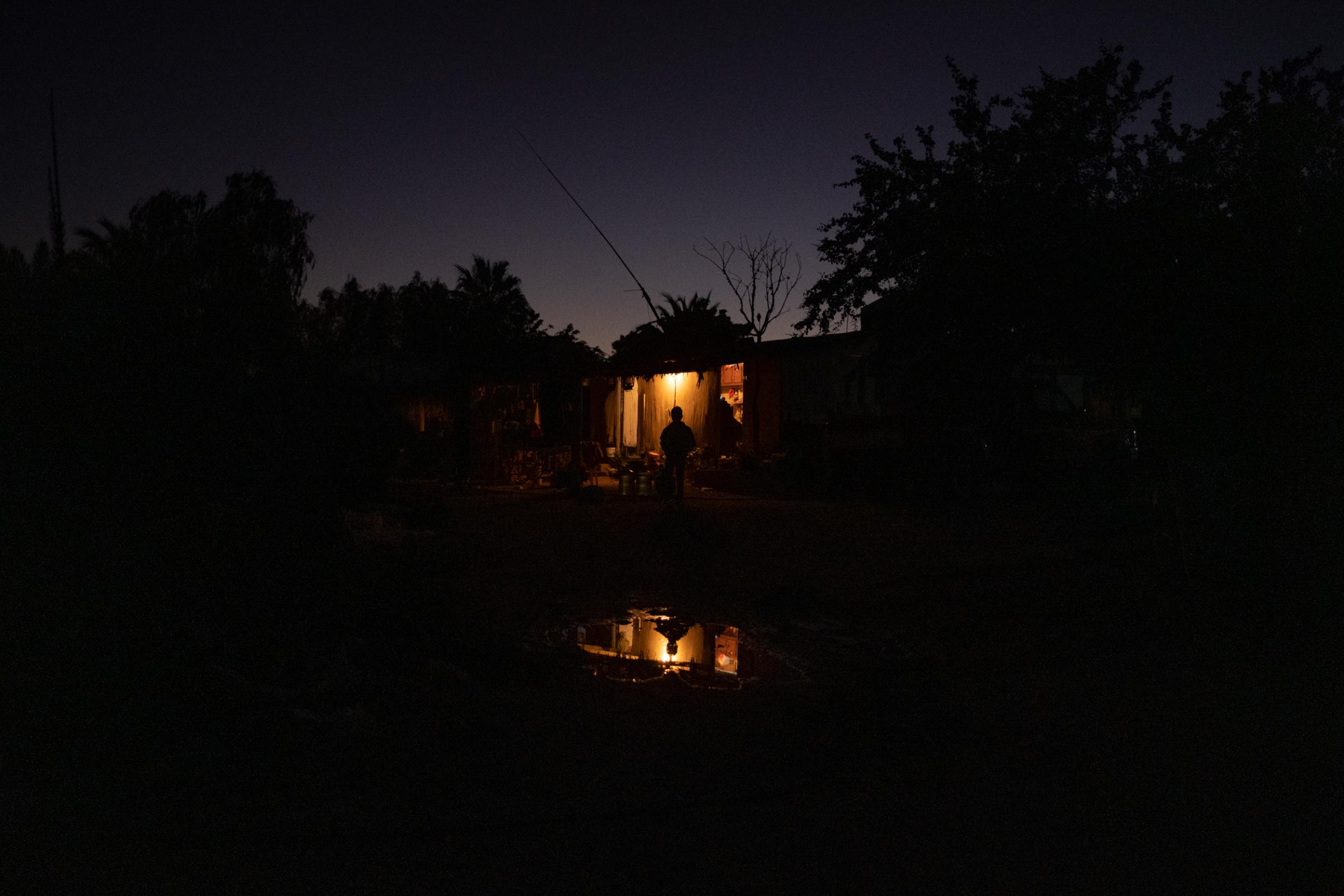 Wider project Until We Are Gone - Joan stands outside his neighbor's house at night in...