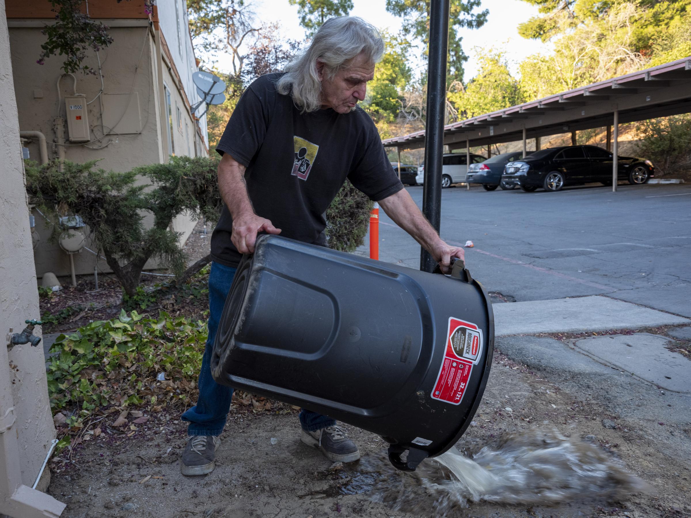 Heat Wave in Antioch - Earnest Hawkins, 74, rinses his trash can after emptying...