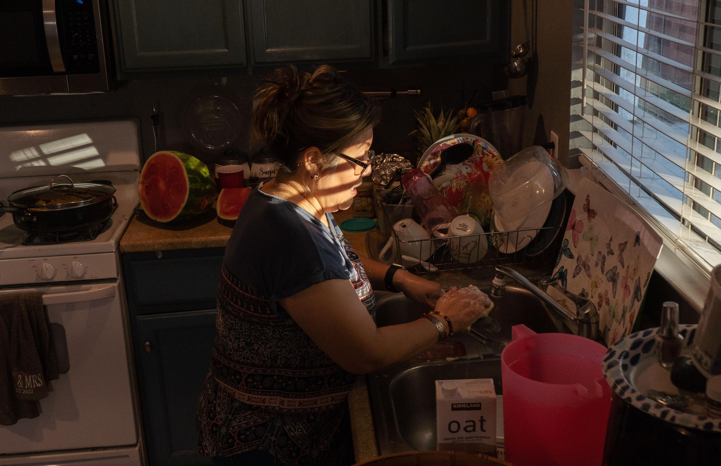 Lack of Translation Services for the Latino Community - Griselda Juarez does the dishes after dinner at her home...