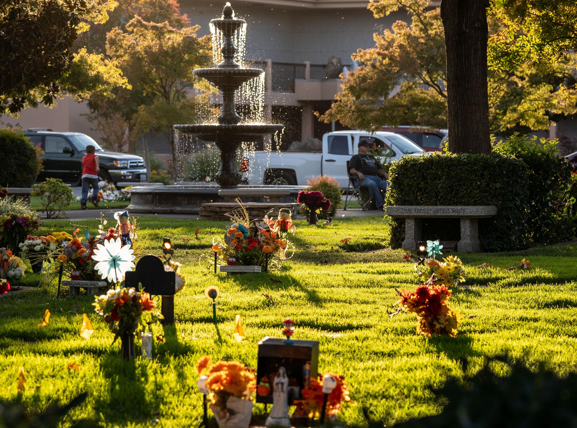 Dia de los Muertos - Grave plaques are decorated with marigold flowers during...