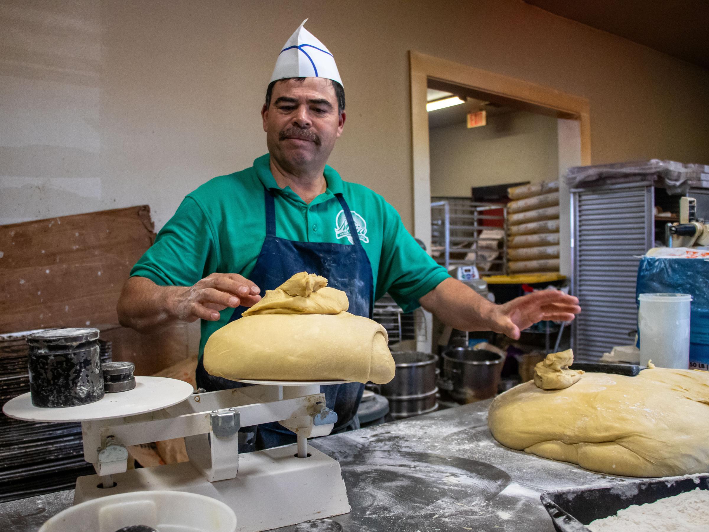 Dia de los Muertos - Jorge Mejia weighs dough for Pan de Muerto (Bread of the...