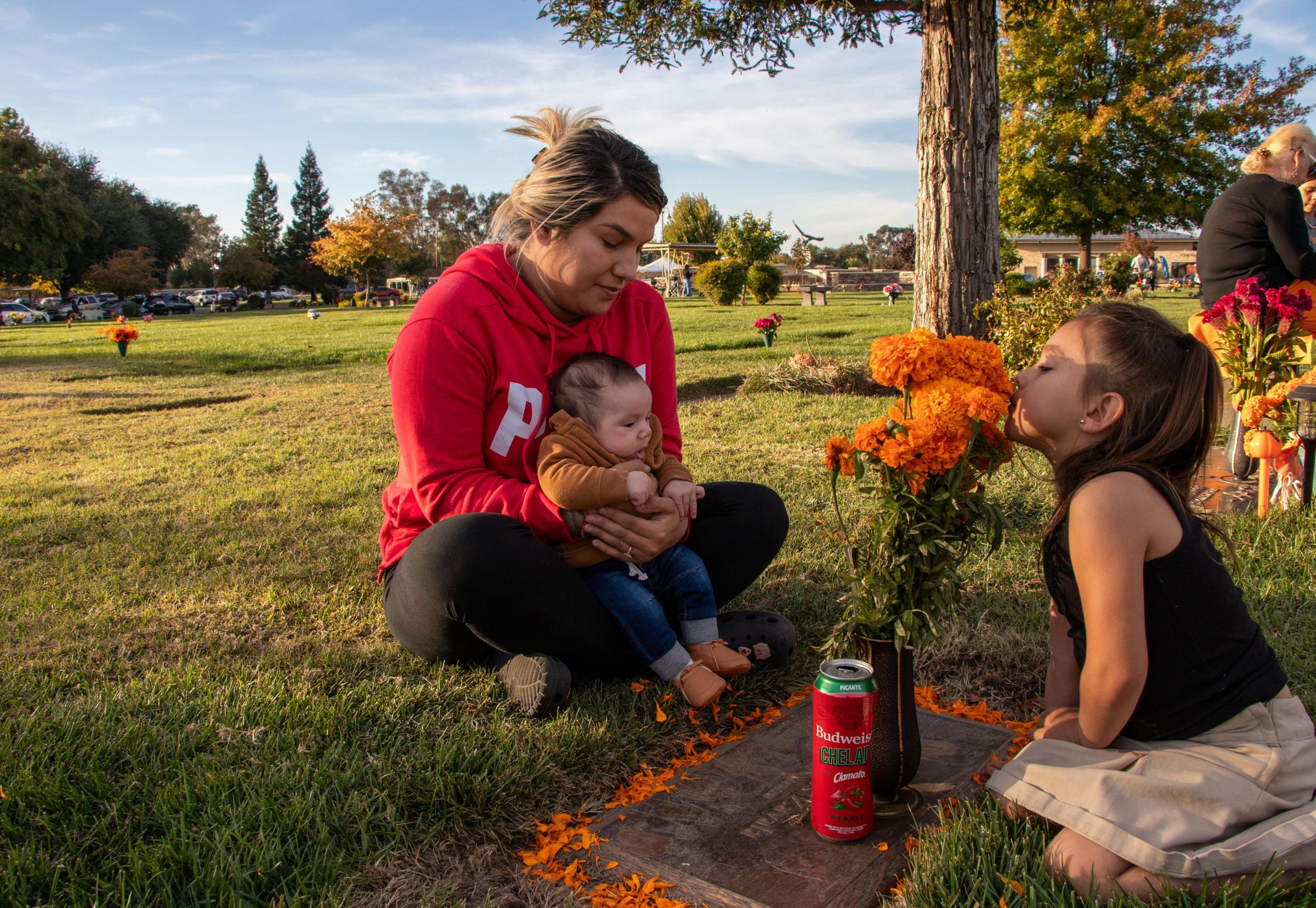 Dia de los Muertos - Kimberly Zavala (left) sits down at her her father Juan...