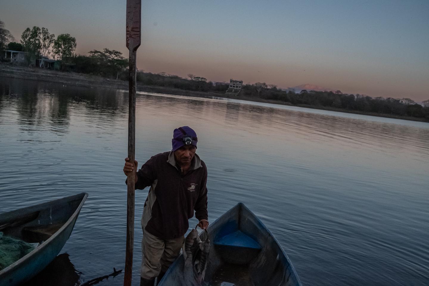 The announced death of the Lempa River - Don Maximiliano Perez, carries in his hand the fish he...