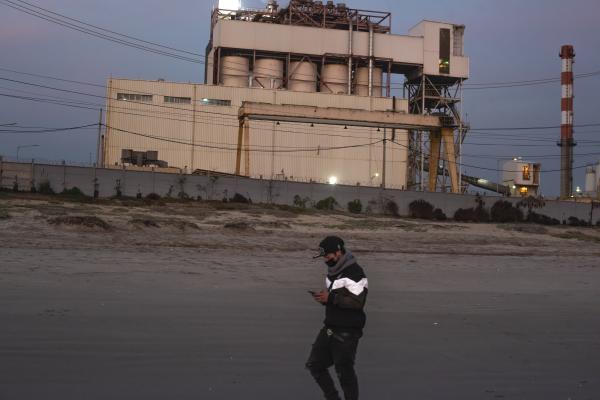 A teenager walks past the AES Geners thermoelectric plant | Buy this image