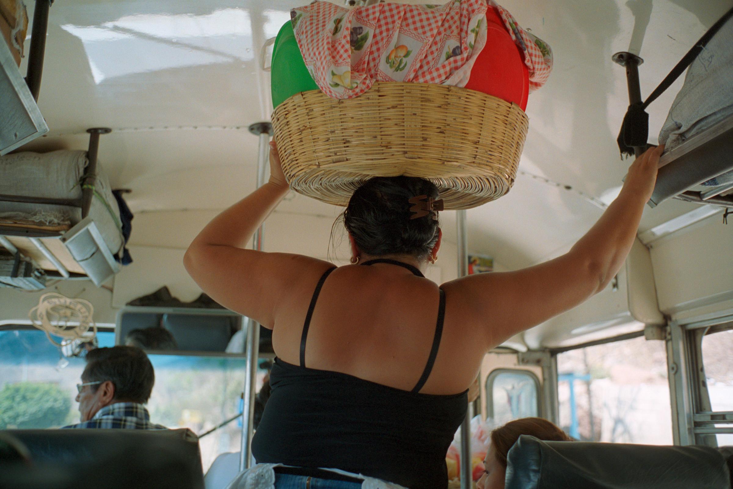 With God and Ayudante Across Guatemala - A saleswoman carries her merchandise, tortillas, in a...