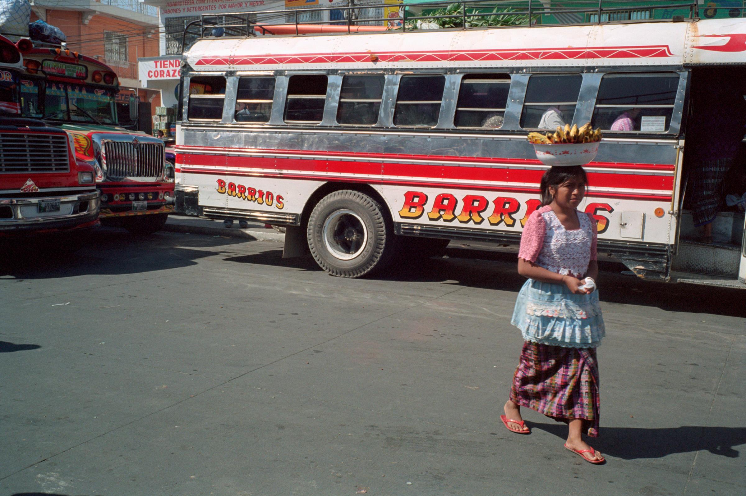 With God and Ayudante Across Guatemala - A saleswoman carries a dish full of bananas on her head...
