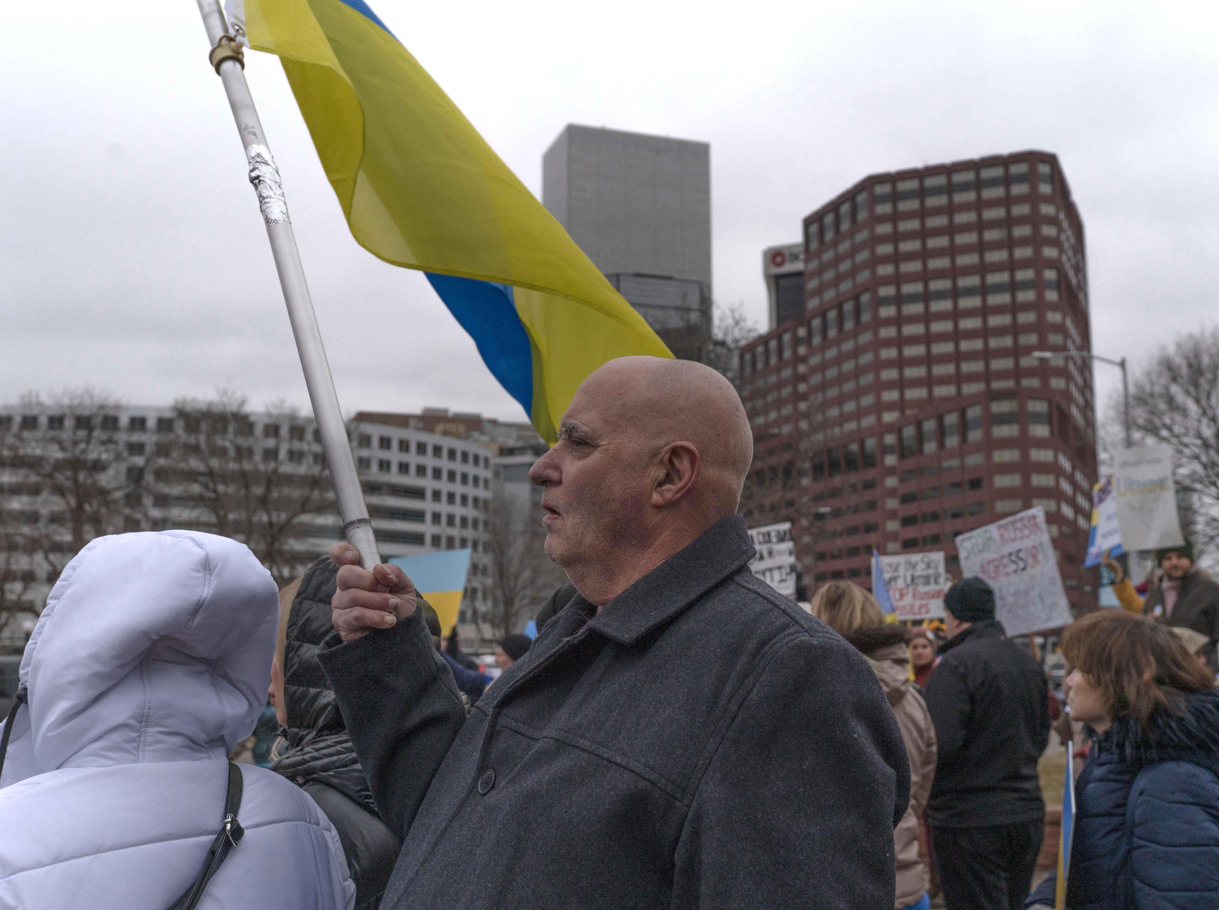 Slava Ukraini - A man walks by with a Ukrainian flag in hand during a...