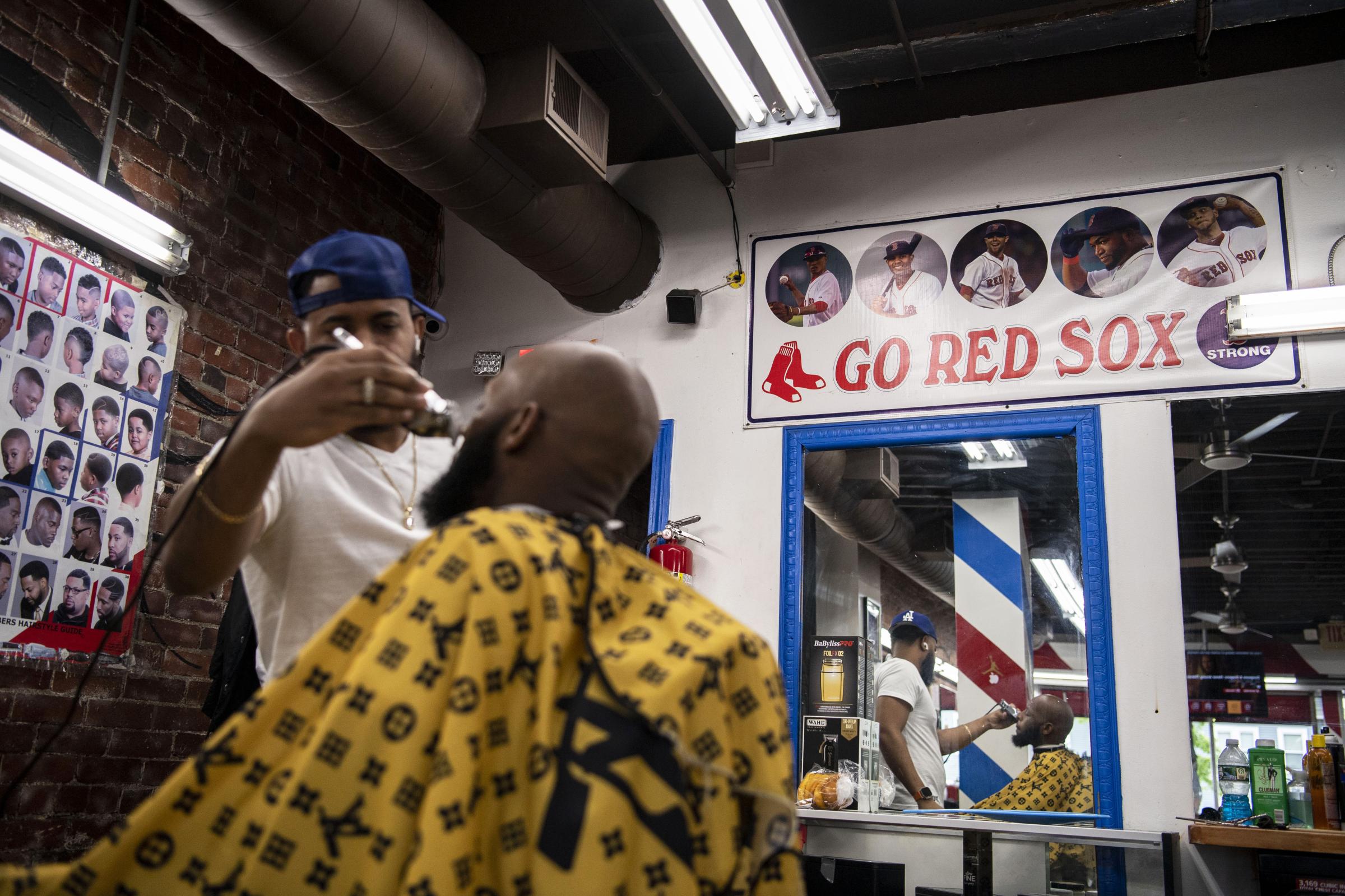 Barbershops - June 7, 2023, Boston, MA:A barber works on a customer in...