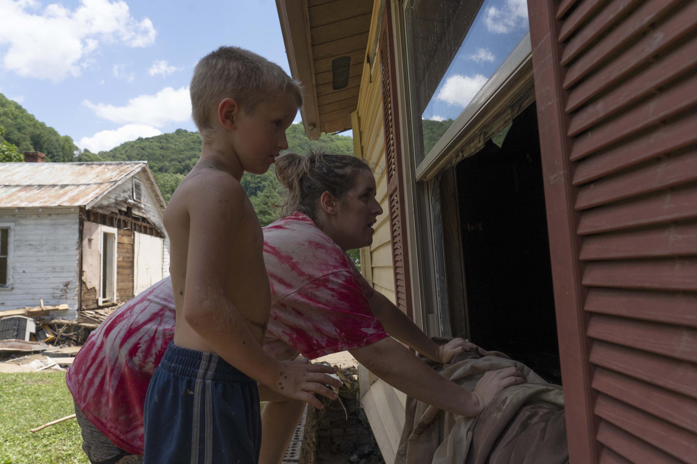 Flooding In Appalachia - Amber Mosley and her son Colton, 6, wait for salvaged...