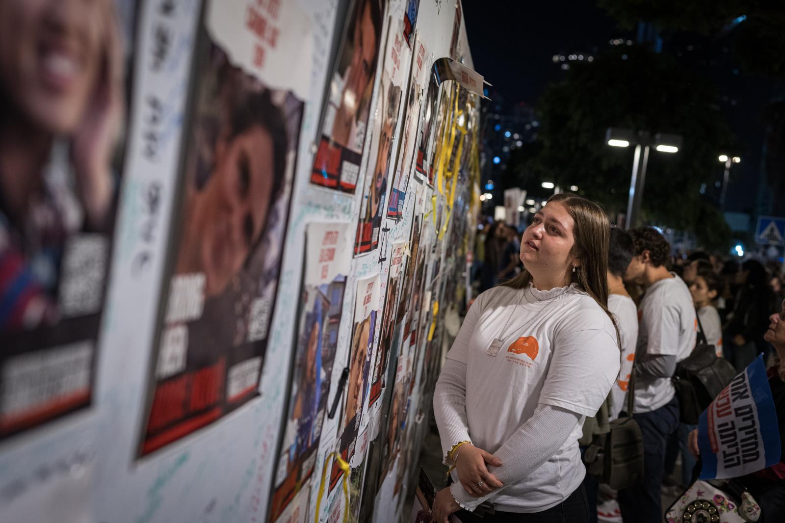 Israel, an announced war - A girl looks at photographs of the hostages captured by Hamas in what is known as Hostage Square...