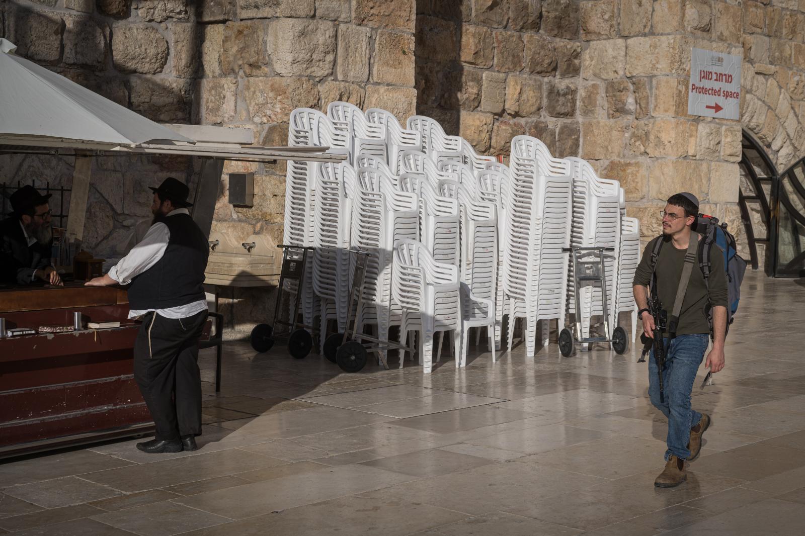 Israel, an announced war - A young man carries a gun in the Western Wall compound in Jerusalem.  