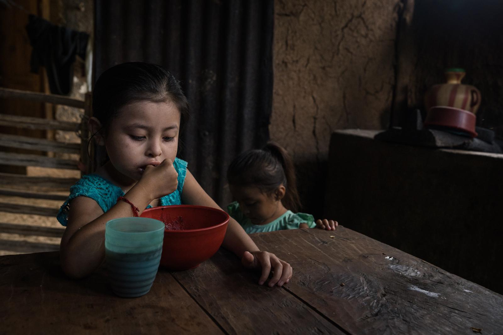 The Dry Corridor: How climate change causes mass migration from Central America - Mabelin Yorleni (6) looks at her plate as she finishes her ration. Like her sister, Mabelin also...