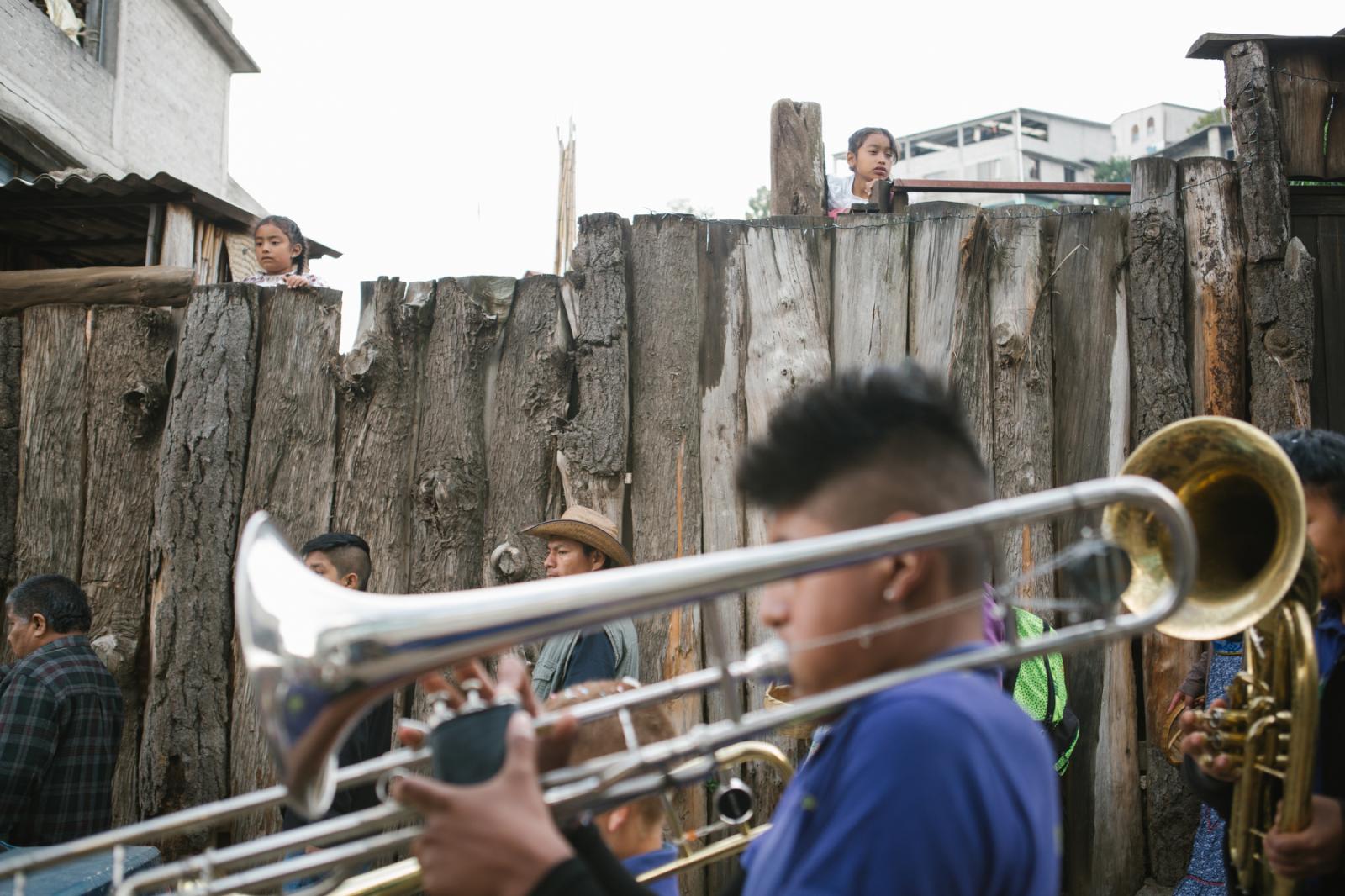 Image from Basketball in the Sierra Norte of Oaxaca - Children peek over a fence to watch a philharmonic band...