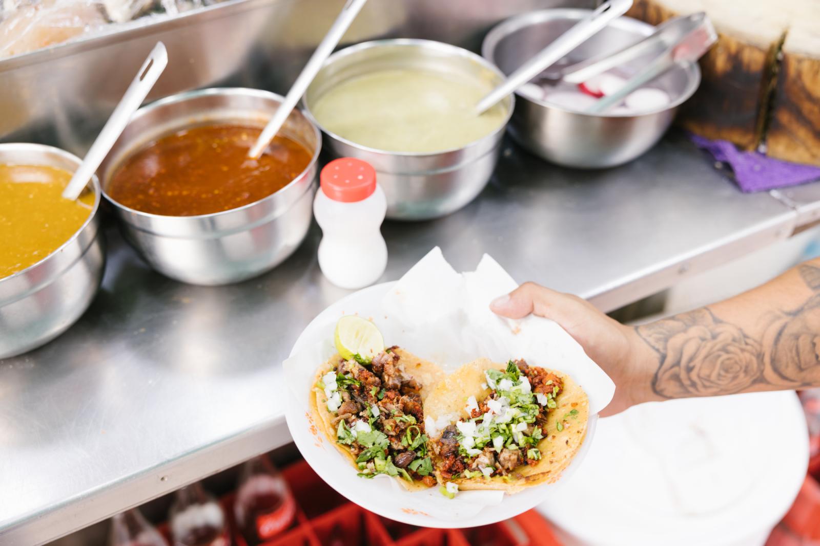 Image from Food & Travel - Mexico City, MEXICO - MAY 25: A patron holds tacos at...
