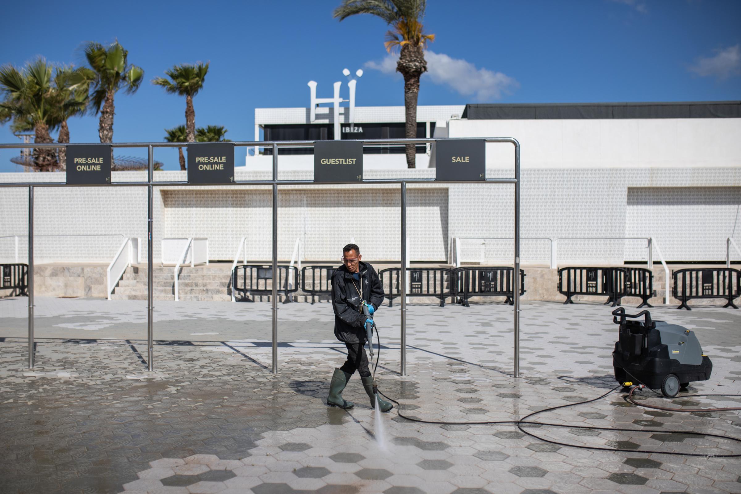 A member of the staff of the H&iuml; discotheque cleans the main entrance of the discotheque with a pressure washer the day before its opening...