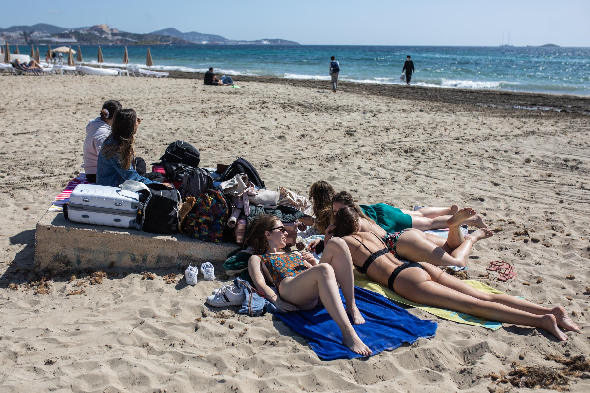 Portuguese tourists with suitcases enjoy their last day at Playa d&#39;en Bossa beach on April 29, 2022 in Ibiza, Spain. The Spanish...