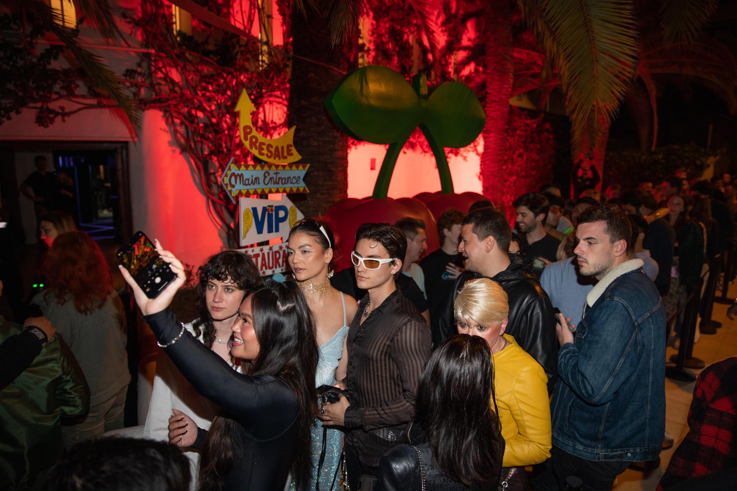 Grand Opening At Pacha Ibiza Heralds A Pre-Pandemic Party Season - Tourists take a selfie with the Pacha disco cherry logo...