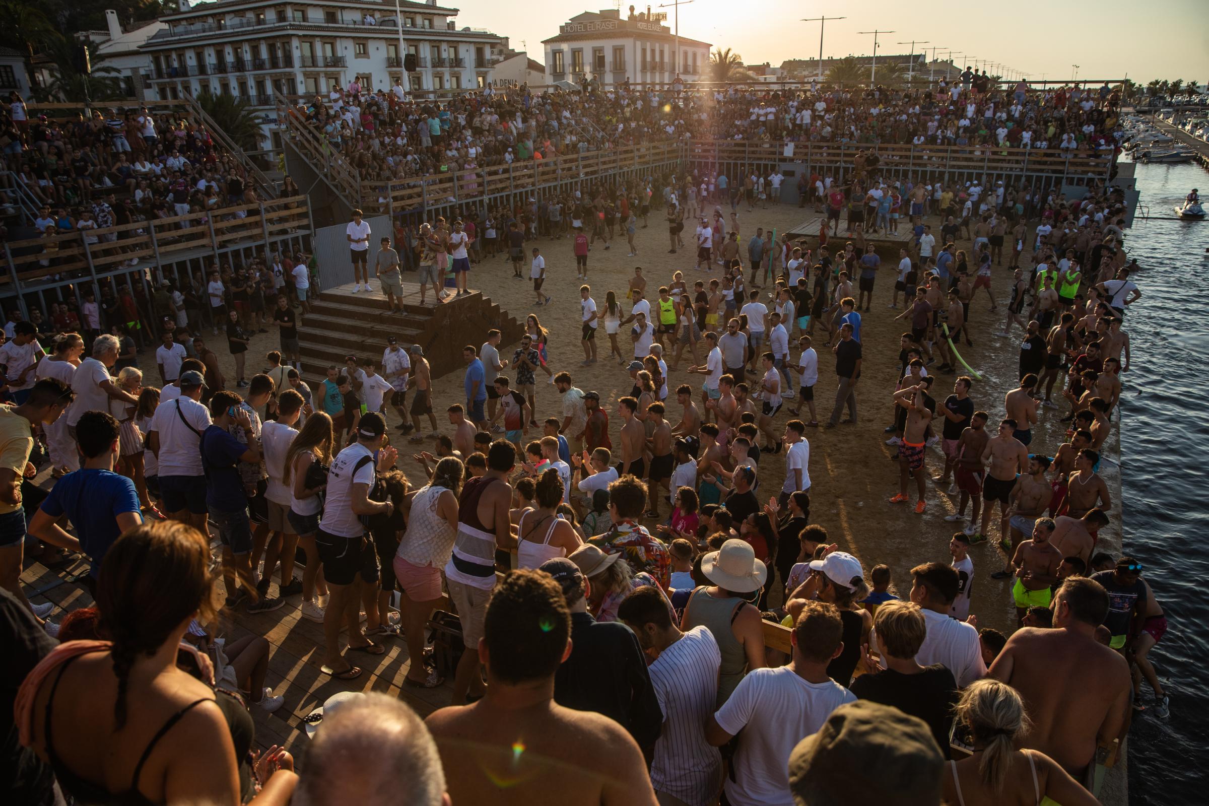 At 'Bous A La Mar', Revelers Take Plunge To Dodge Bulls And Beat The Heat - DENIA, SPAIN - JULY 17: The bull makes the participants...
