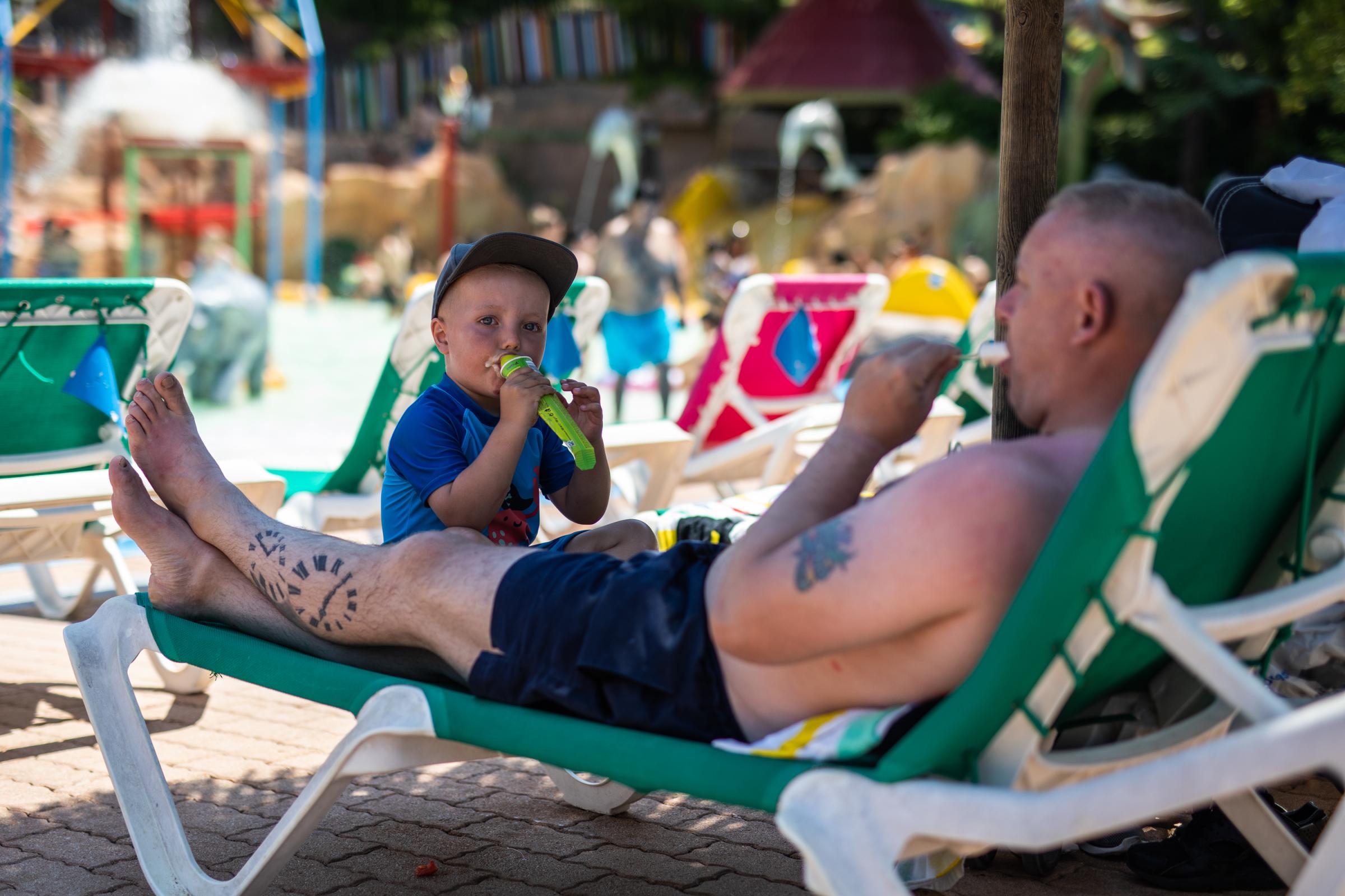 Heatwave Sweeps Across Spain - BENIDORM, SPAIN - JULY 16: A father and son eat an ice...