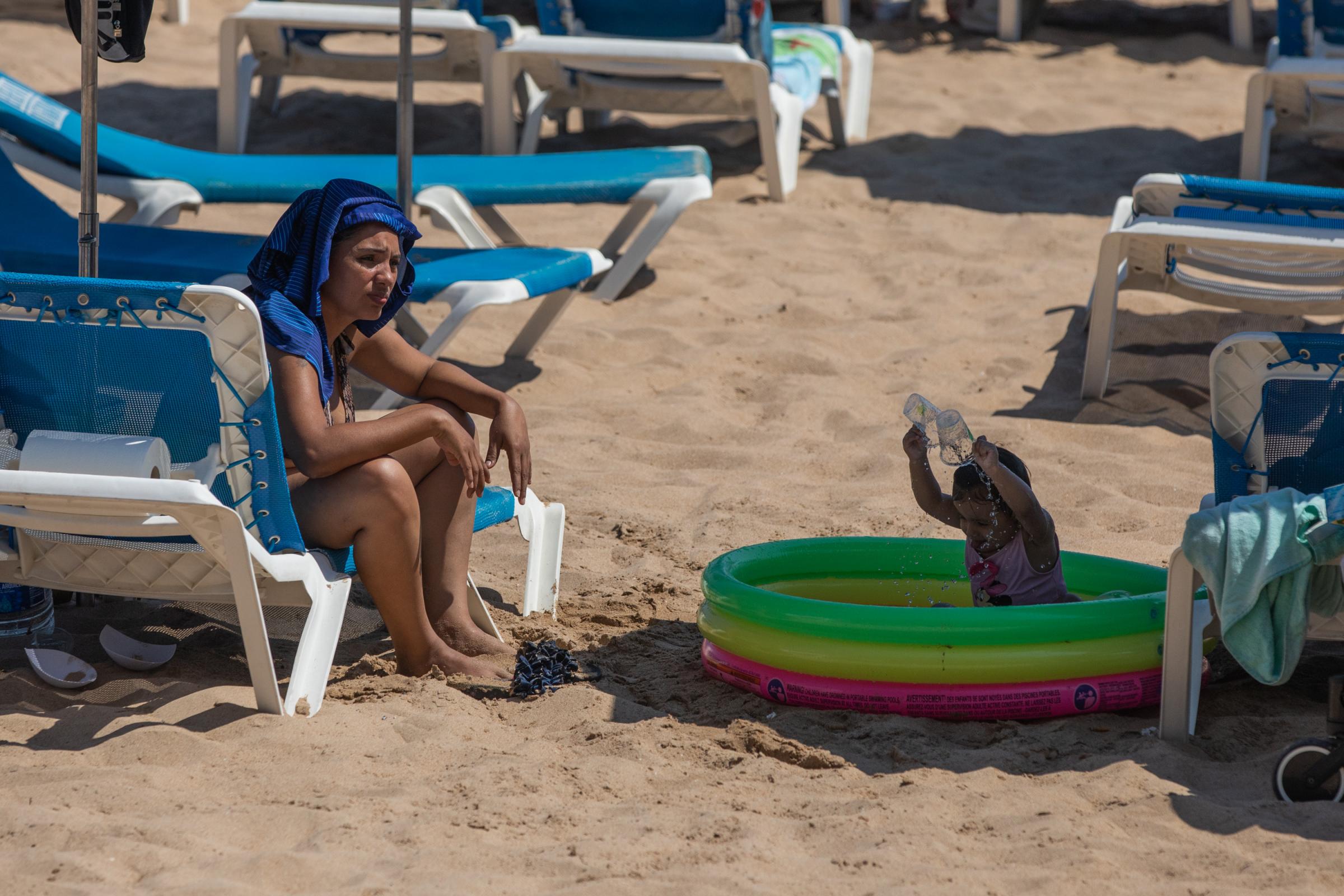 Heatwave Sweeps Across Spain - BENIDORM, SPAIN - JULY 16: A woman on the beach in the...