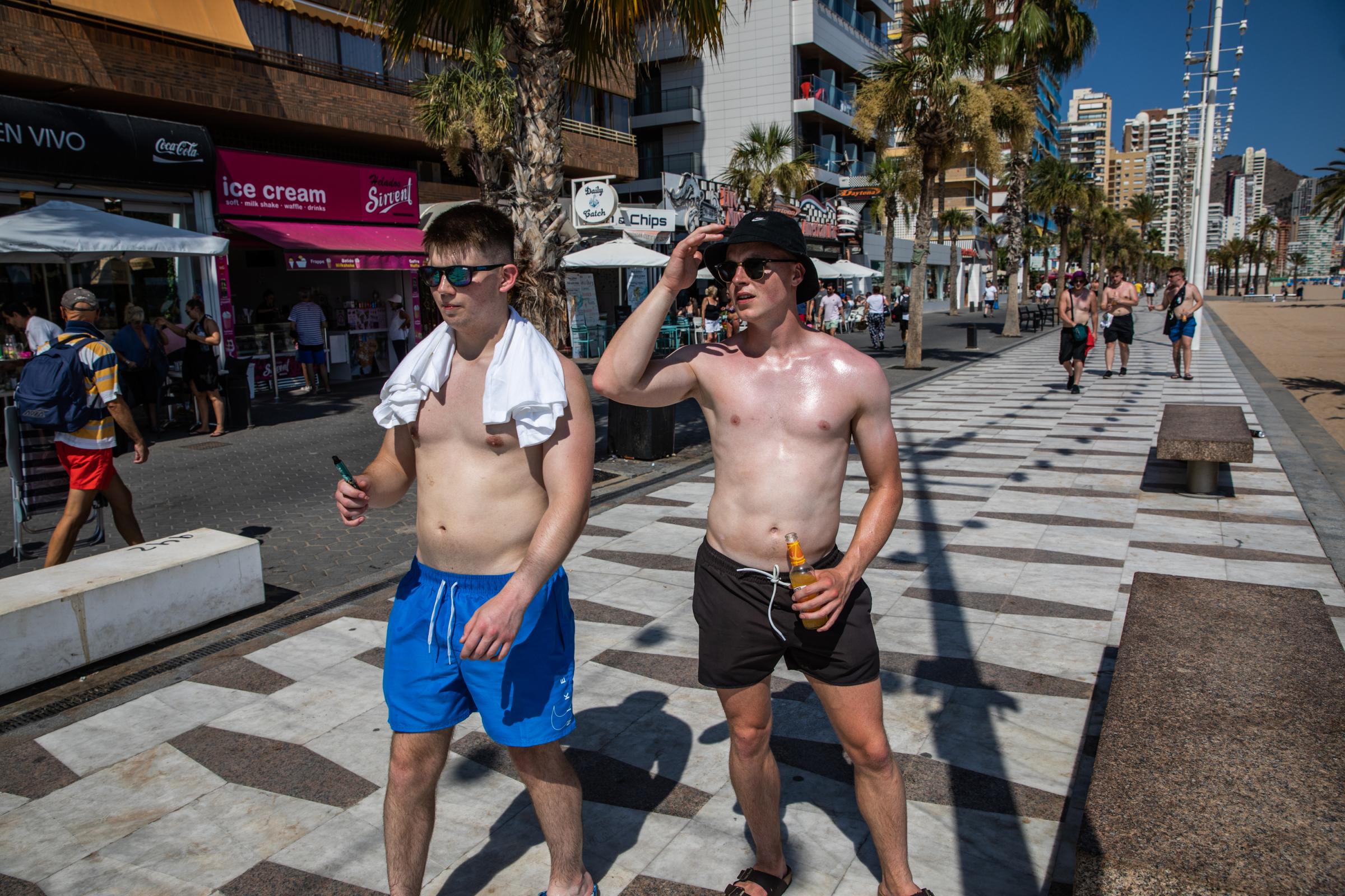 Heatwave Sweeps Across Spain - BENIDORM, SPAIN - JULY 16: Tourists stroll shirtless on...