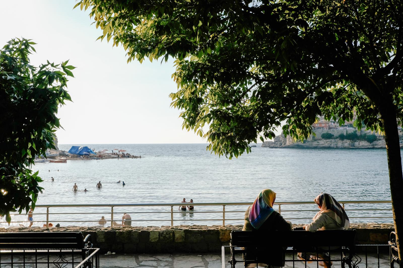 Women chat on a bench overlooki...asra, on the Black Sea, Turkey.