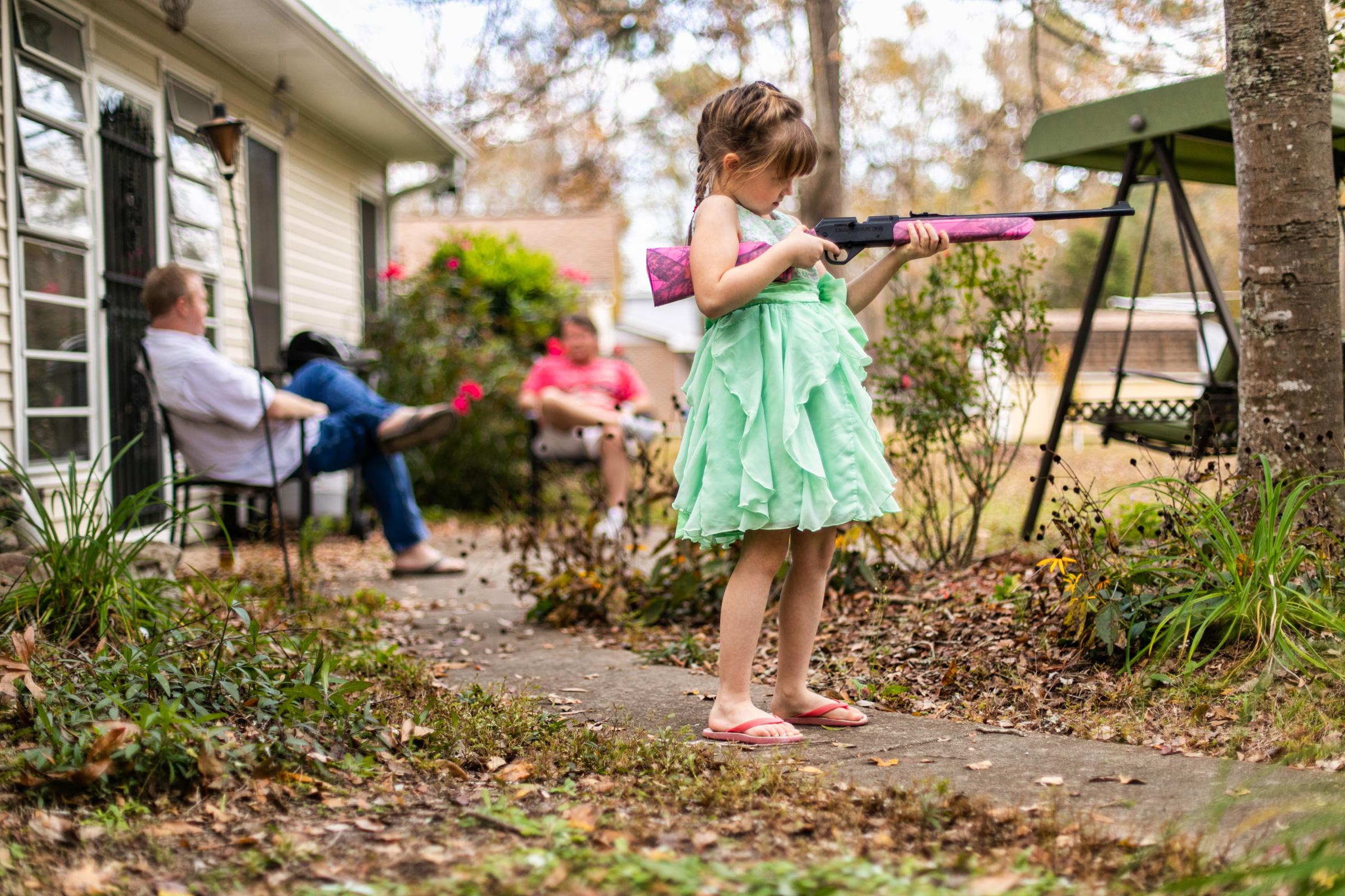 Growing Up - A young girl shows off her pink BB gun during a...