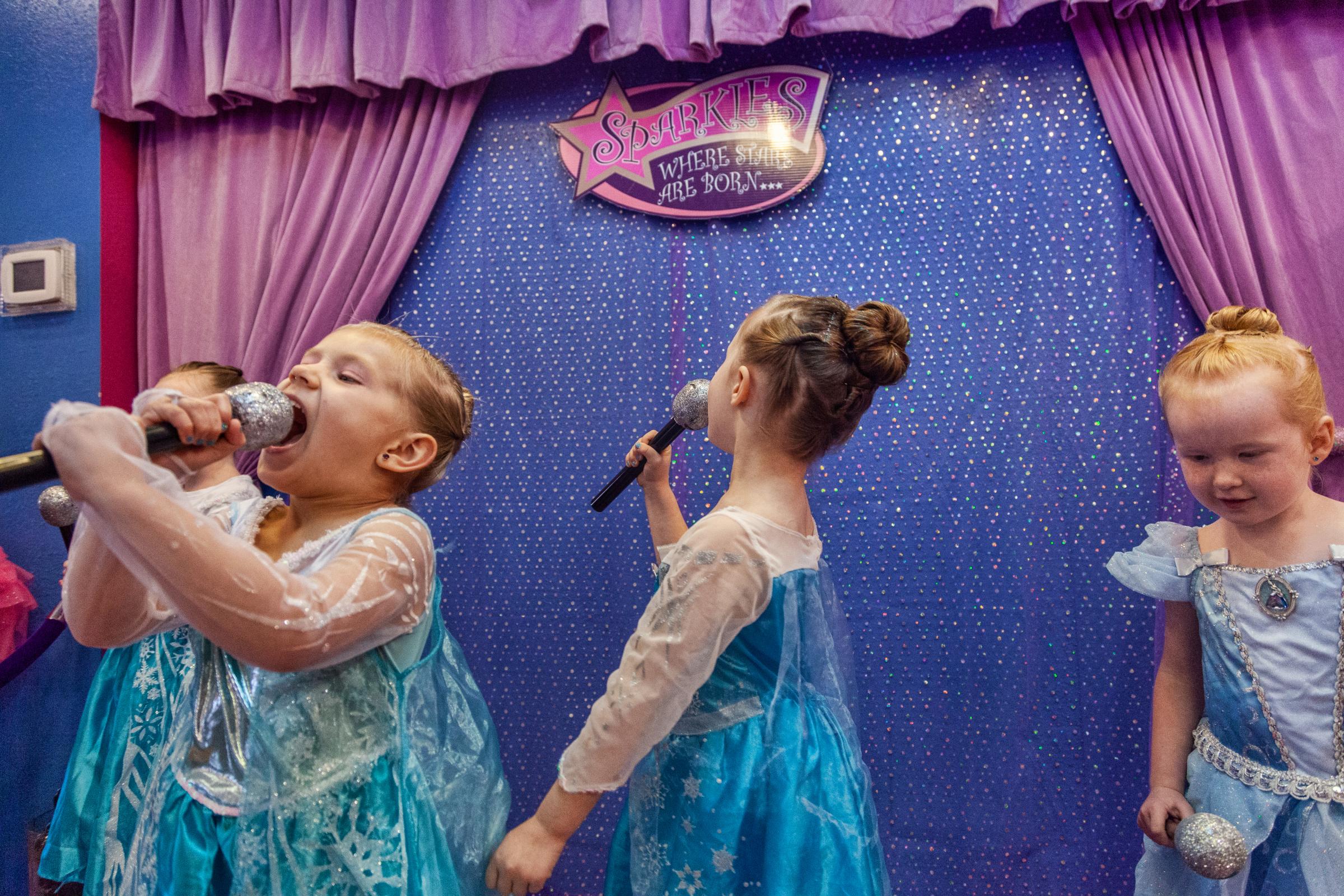Growing Up - Young girls sing onstage during a princess birthday party...