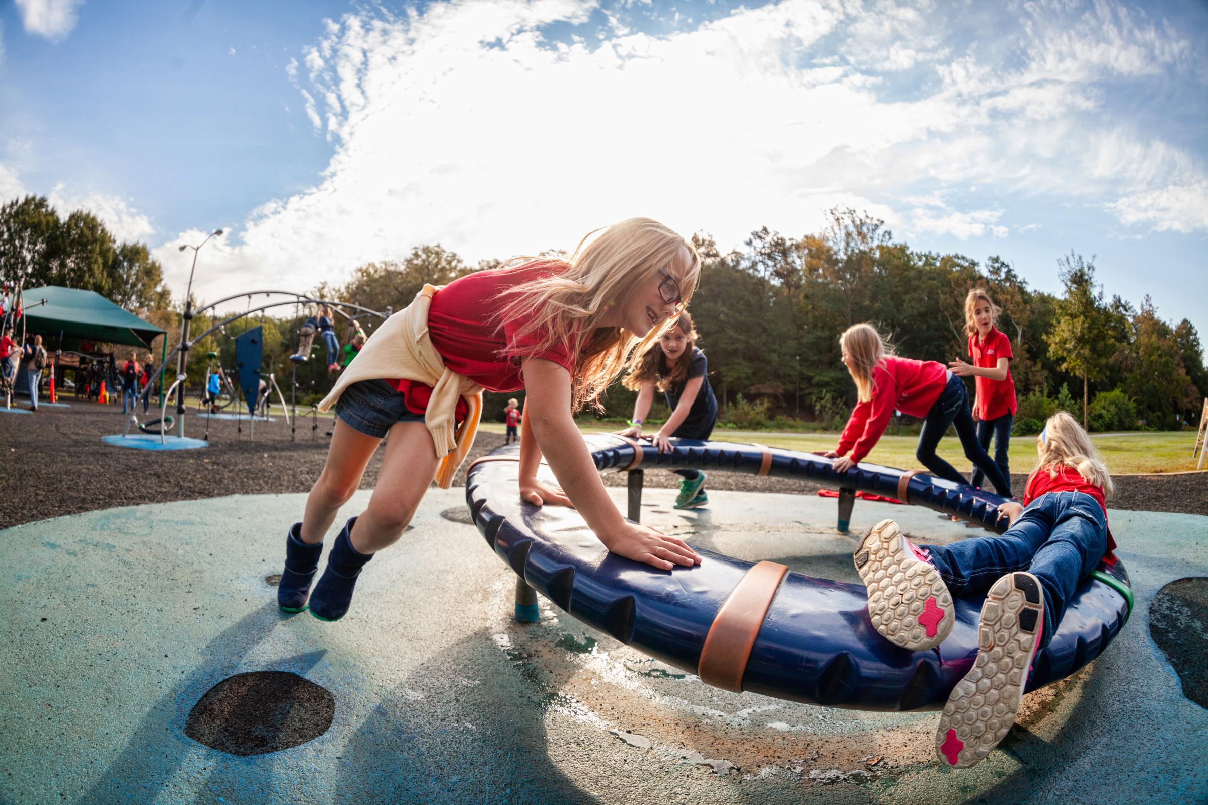 Growing Up - Girls spin on the playground outside the zoo in...
