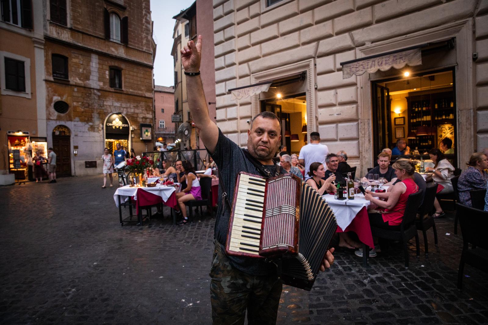 A man plays accordion for diner...onda near the Pantheon in Rome.
