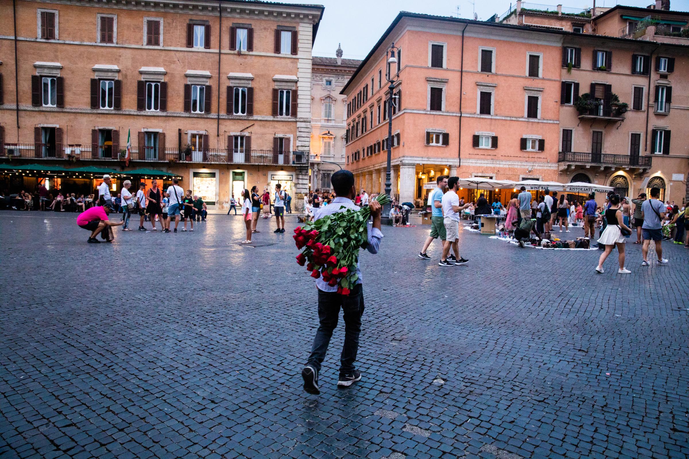 That Bad Boy Rome - A First-timer's Perspective - A man sells roses along the Piazza Navona in Rome.