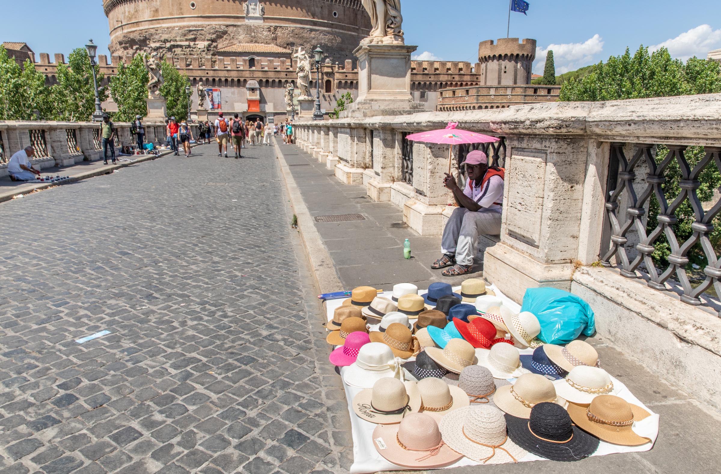 That Bad Boy Rome - A First-timer's Perspective - Vendors sell hats along the entrance to Castel Sant&#39;Angelo in Rome during extremely high...