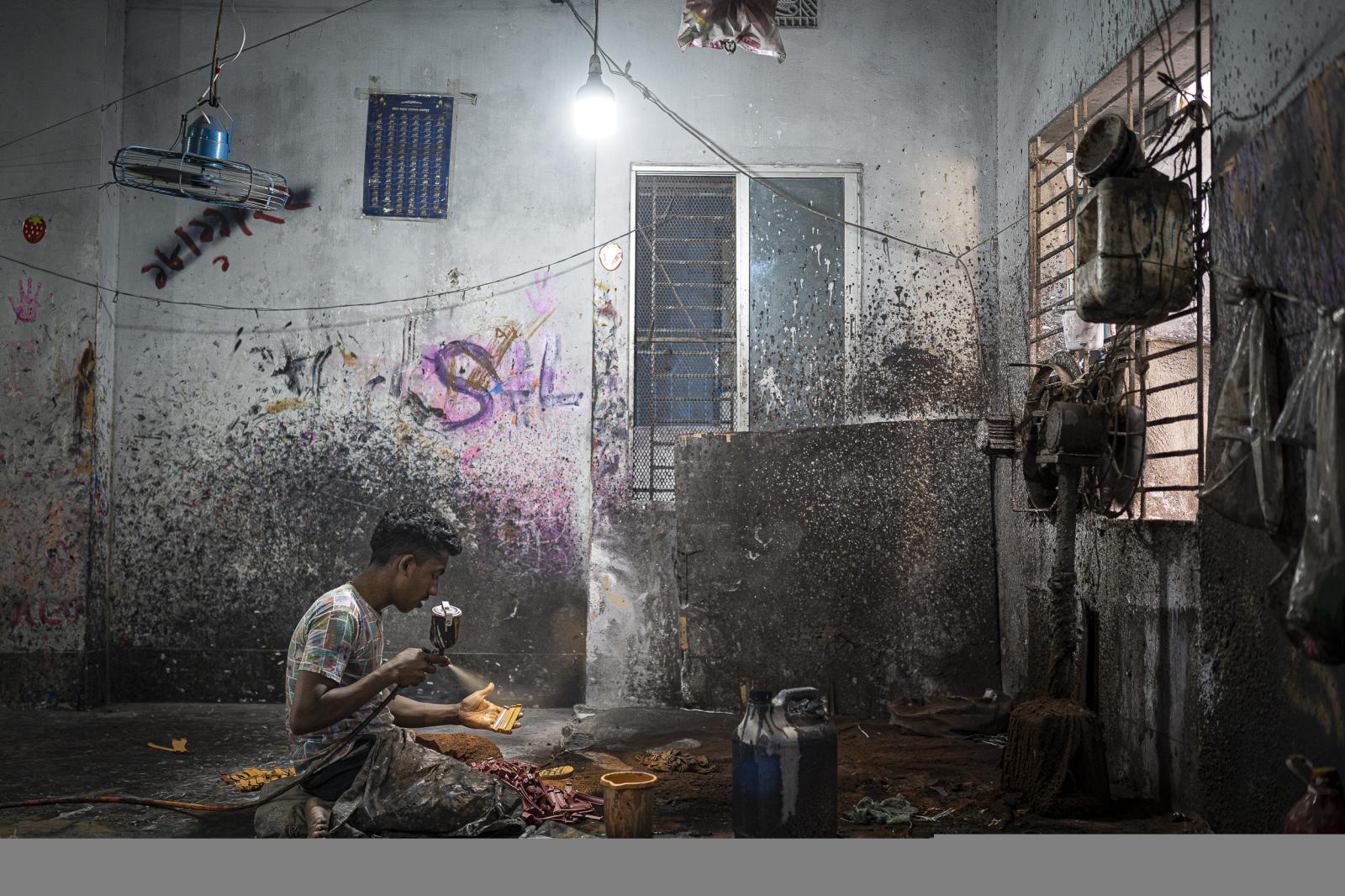 Beyond the storm -  A worker in a recycled shoe factory in the Lalbagh...
