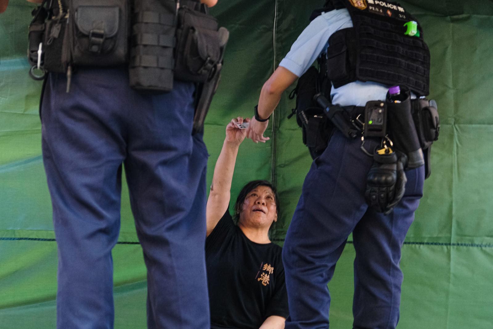A woman is being stopped and se...nised by 26 pro-Beijing groups.