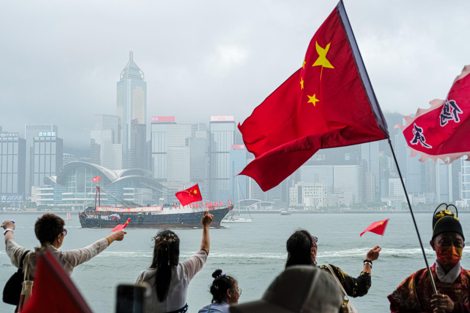 People wave Chinese flags durin...rom Britain to China on July 1.