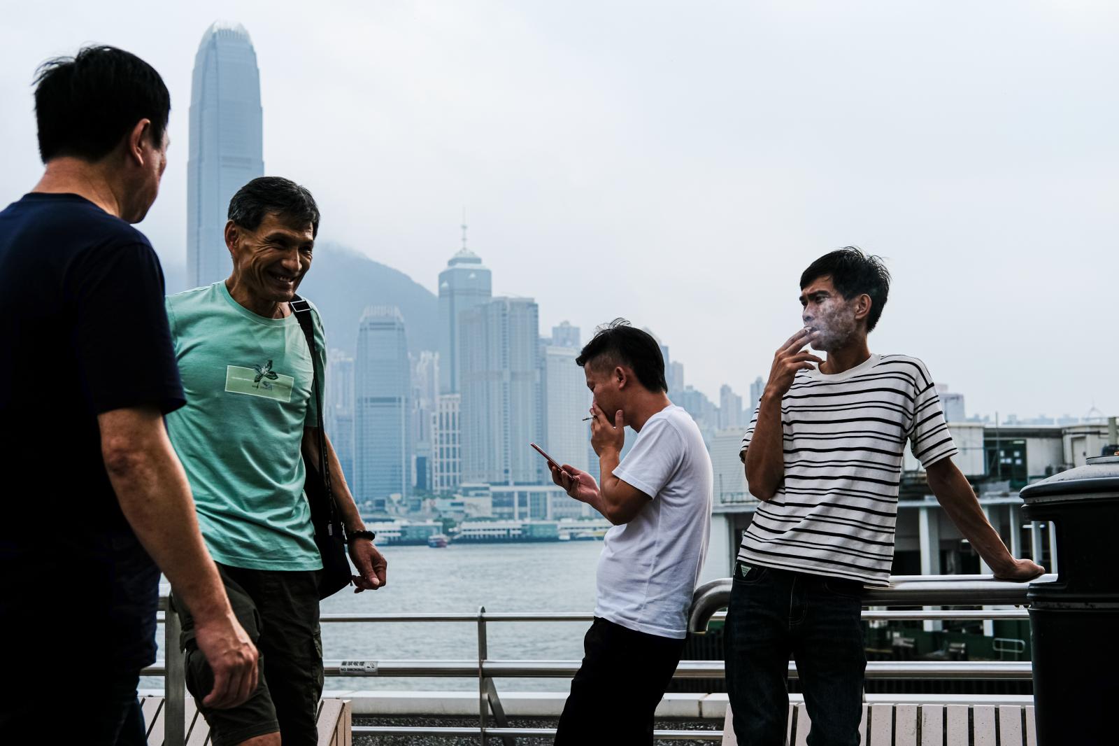 Mainland Chinese tourists smoke...ar Ferry pier in Tsim Sha Tsui.