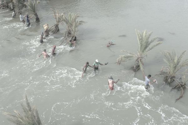Image from Salt Water's Roar -   During the aftermath, people crossed a broken, flooded...